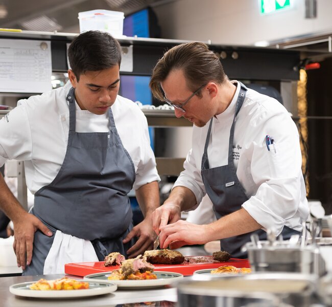 SHL Student getting a instruction from a lecturer in the kitchen. | © SHL